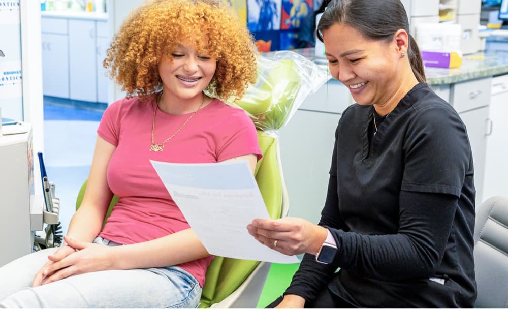 teen patient smiling with orthodontic assistant